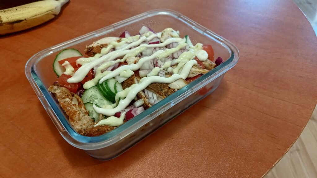 Zdjęcie przestawiające "sałatkę kebab" polaną sosem.