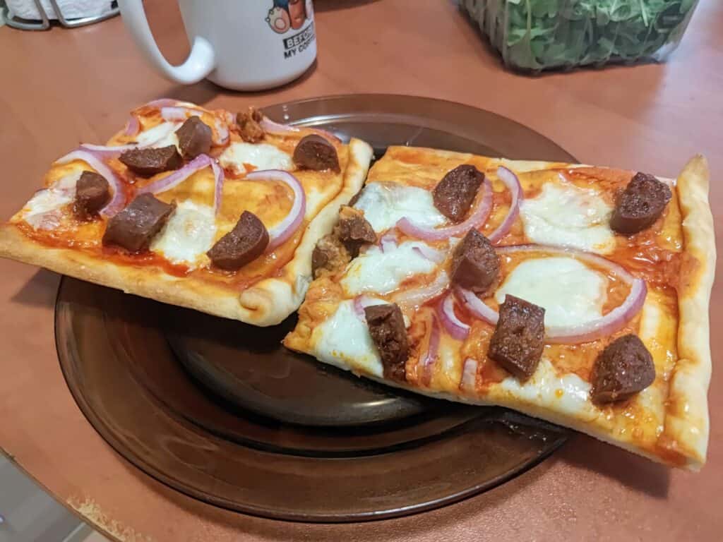 Zdjęcie pizzy z czerwonym pesto, mozarellą, chorizo i niewielkim dodatkiem miodu