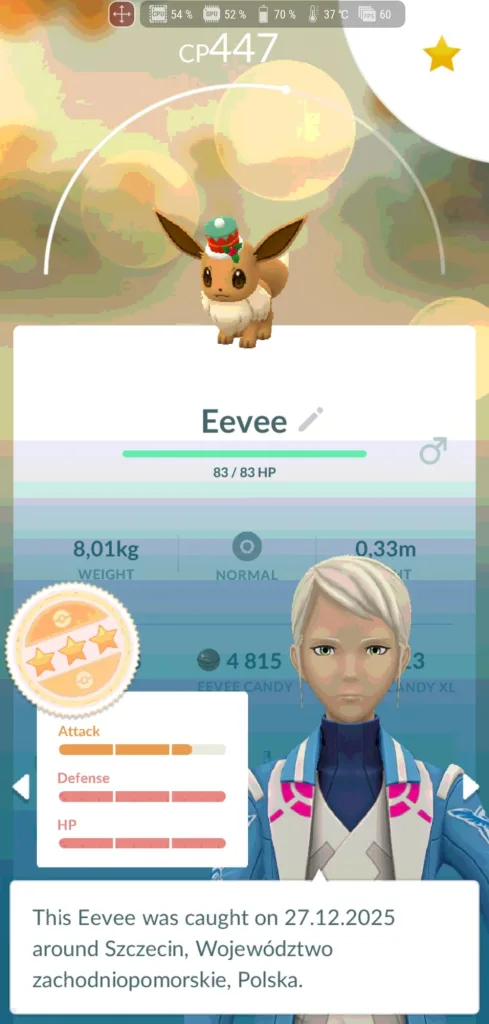 Eevee w małej świątecznej czapeczce z pomponem na ekranie parametrów w grze mobilnej Pokemon GO.