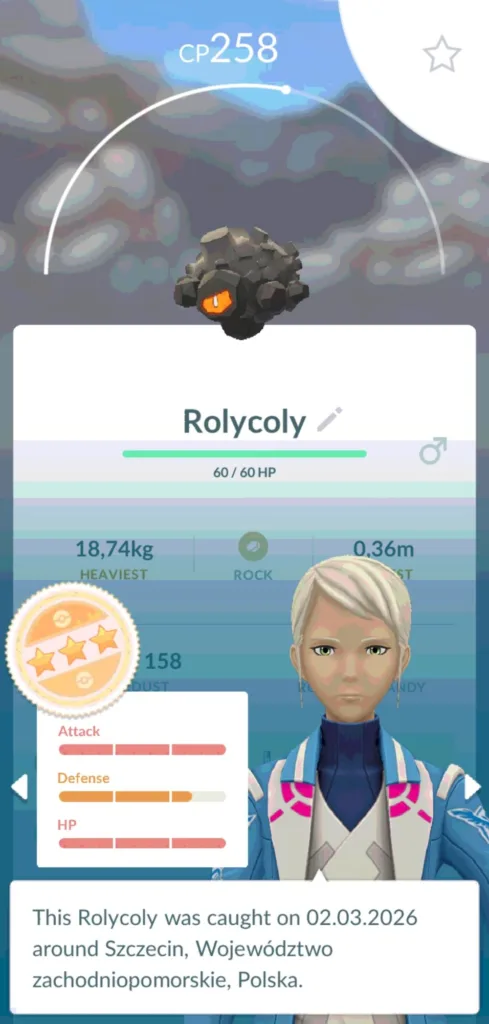 Szary, kamienny Pokemon Rolycoly z pomarańczowym okiem, z widocznym paskiem CP 258 i statystykami