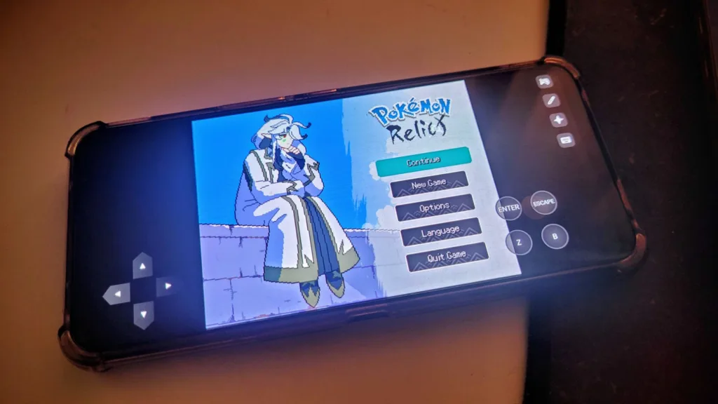 Postać z gry komputerowej Pokemon Relict siedzi na murku, na ekranie telefonu widoczne jest menu gry z opcjami kontynuuj, nowa gra, opcje, język i wyjdź.