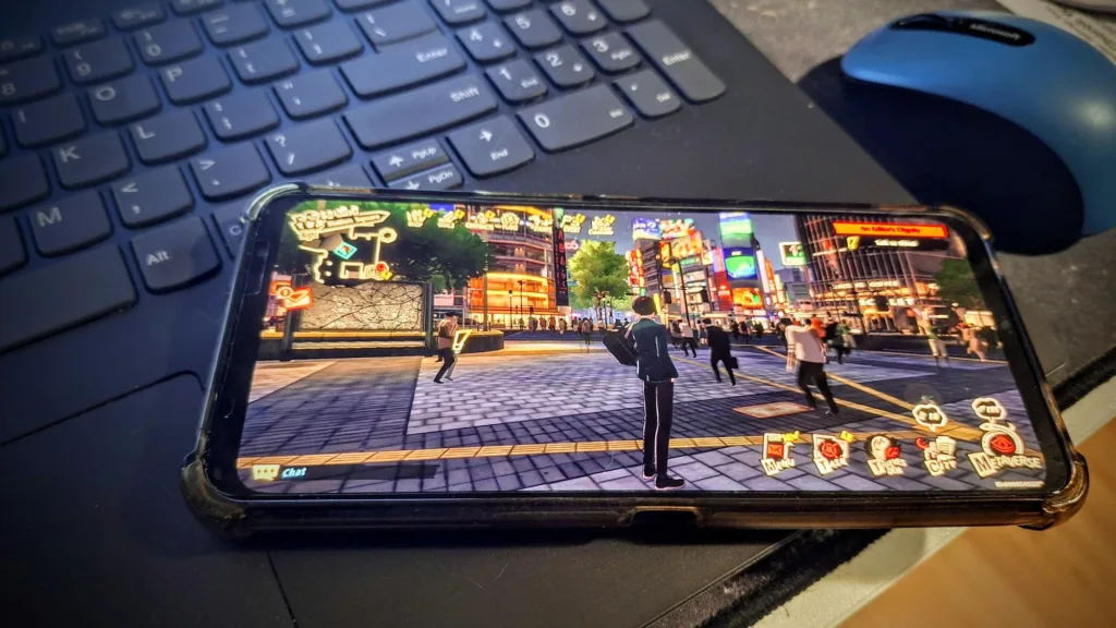 Smartfon wyświetla grę Persona 5 X z widokiem na ruchliwą ulicę miasta nocą, z neonowymi światłami i postaciami