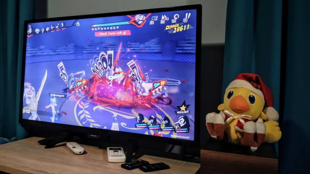 Kadr z gry Persona 5 The Phantom X pokazujący dynamiczną walkę z efektami wizualnymi i postaciami.