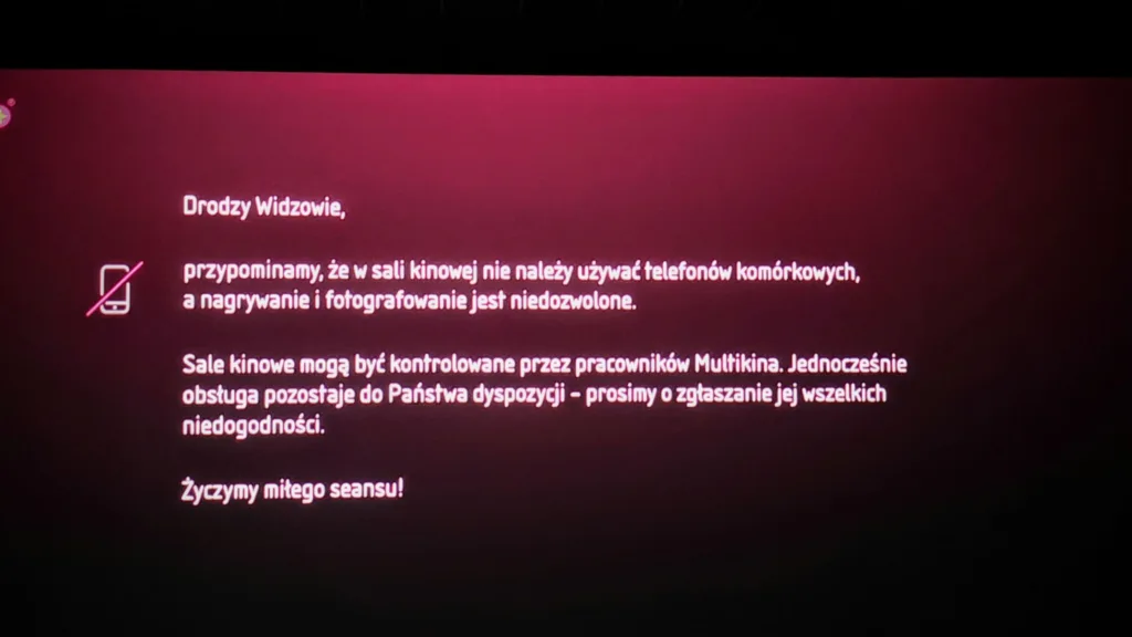 Komunikat w sali kinowej informujący, że używanie telefonów komórkowych, nagrywanie i fotografowanie jest niedozwolone.