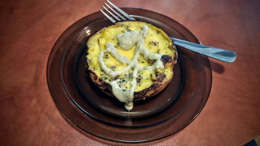Okrągły omlet z sosem na brązowym talerzu