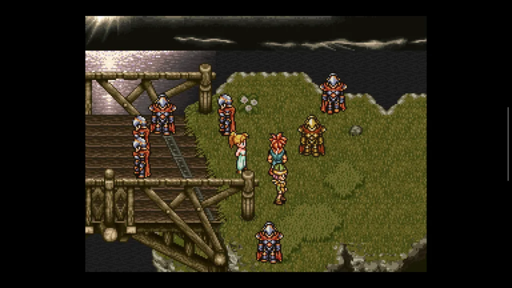 Grupa postaci w pixel artowej stylistyce stoi na drewnianym moście i zielonym brzegu w grze Chrono Trigger.
